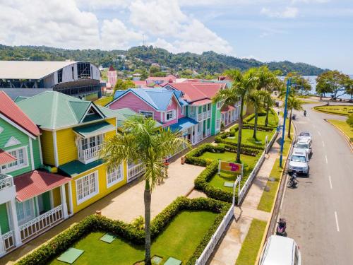 una calle de la ciudad con casas coloridas y palmeras en Villa Dylan Samana, 3Br with pool, en Santa Bárbara de Samaná