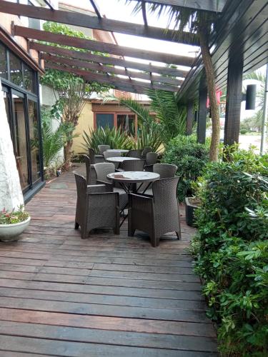 a patio with tables and chairs on a wooden deck at Hotel Bahia in La Paloma