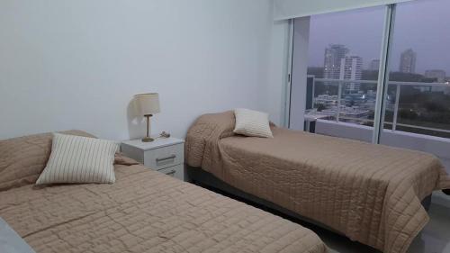 due letti in una camera da letto con vista sulla città di Edificio Botavara a Punta del Este