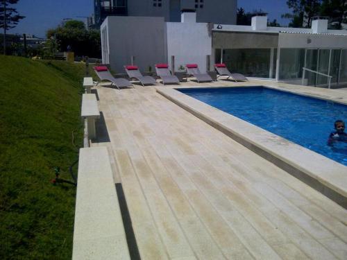 una piscina con sedie a sdraio accanto a una piscina di Edificio Botavara a Punta del Este