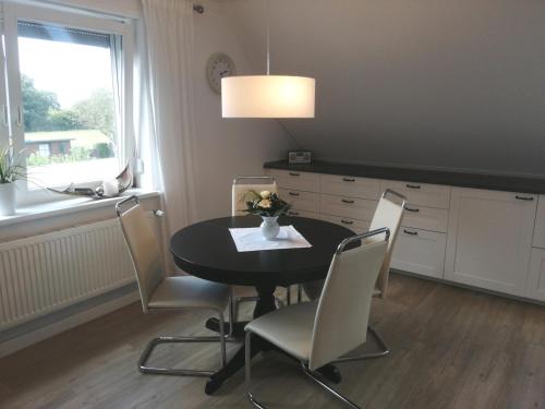 a dining room with a black table and chairs at Ostsee-Auszeit in Stakendorf