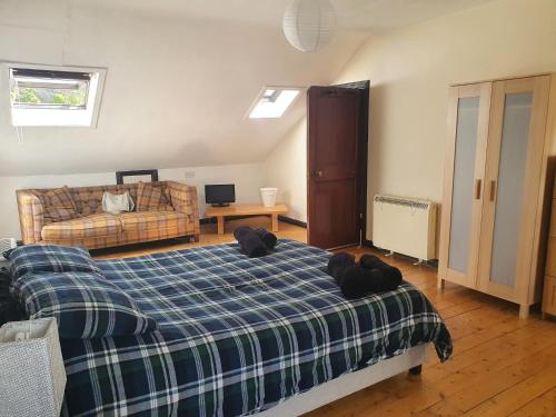 a bedroom with a bed and a couch at Argyll Mansions Penthouse in Oban
