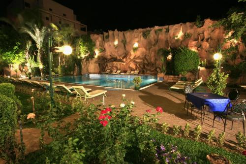 a pool at night with a table and chairs at Imperial Holiday Hôtel & spa in Marrakech