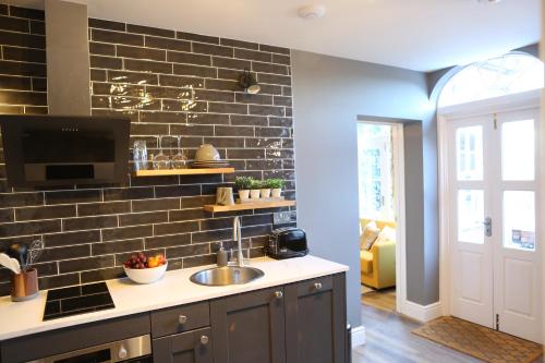 a kitchen with a sink and a brick wall at no 12 - Stunning Self Check-in Apartments in Worcester Centre in Worcester