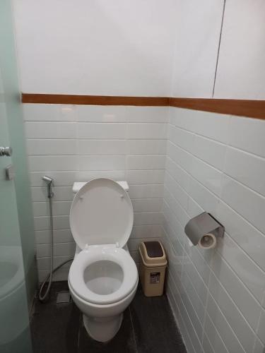 a bathroom with a toilet and a trash can at Nindya Biodistrict Hotel Bandung in Bandung