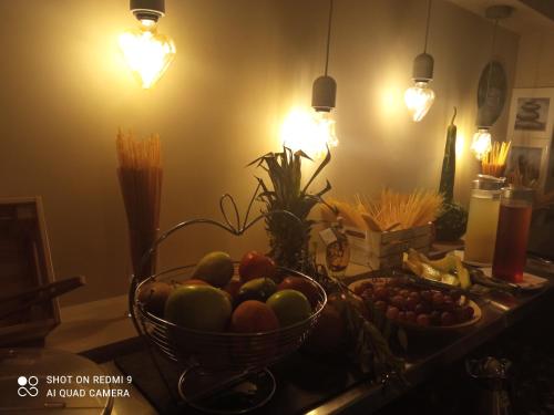 a kitchen counter with a bowl of fruit and vegetables at City Gate Hotel Airport Thessaloniki in Thessaloniki