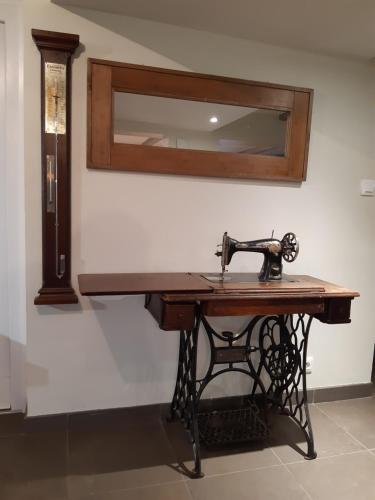 a sewing machine on a table with a mirror at Gîte de la Grande Rainette in Grosne