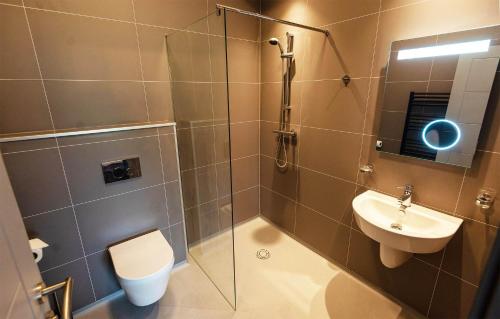ein Bad mit einer Dusche, einem WC und einem Waschbecken in der Unterkunft Kinloch Ainort Apartments in Luib