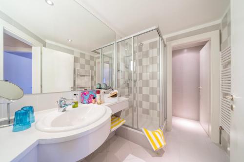 a white bathroom with a sink and a shower at Gästehaus Schusser an der Therme in Bad Kleinkirchheim