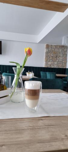 a vase with a flower and a bowl on a table at Vale Humor Residence in Mănăstirea Humorului