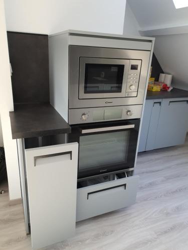 une cuisine avec un micro-ondes et une cuisinière dans l'établissement La Marina, à Saint-Jean-de-Losne