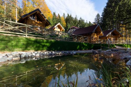 una cabaña en el bosque junto a un estanque en Green Village Ruševec, en Hočko Pohorje