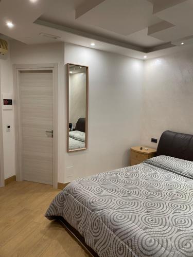 a bedroom with a bed and a mirror on the wall at B&B Rossini Luxury 2 in Cosenza
