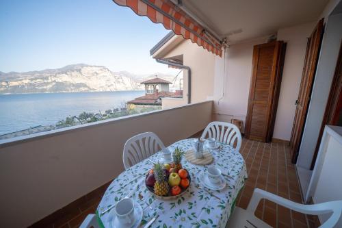 a table with a bowl of fruit on a balcony at Peler Beth's House in Brenzone sul Garda