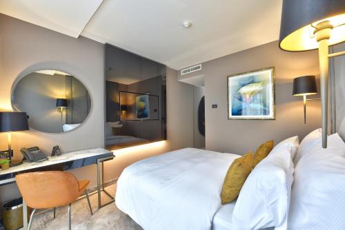 a bedroom with a bed and a desk and a mirror at Grand Hotel Adriatic in Opatija