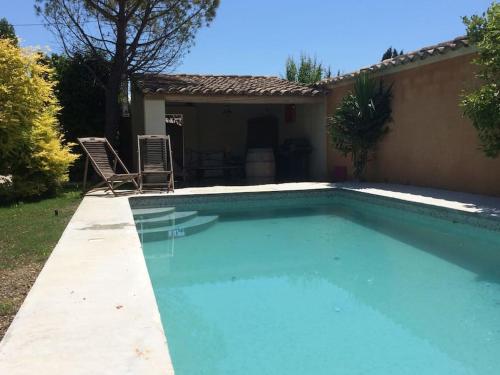 - une piscine en face d'une maison dans l'établissement Belle maison provençale au pied du Mont Ventoux, à Caromb