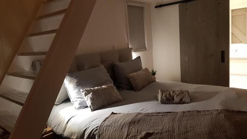 a bed with pillows on it in a bedroom at Logeren bij Grea in Zwartsluis