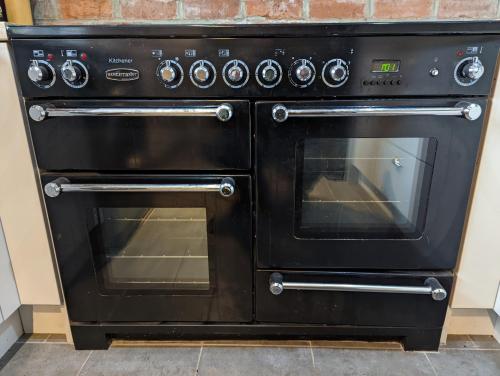 a black oven is sitting in a kitchen at Beautiful rural cottage with secure garden in Bradley