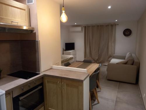 une cuisine et un salon avec une table et un canapé dans l'établissement cosy studio clim mer 1mn, à La Seyne-sur-Mer