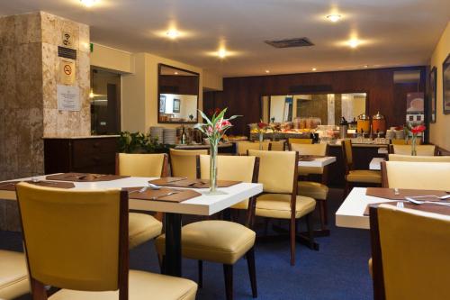 a dining room with tables and chairs in a restaurant at Hotel Rio Lancaster in Rio de Janeiro