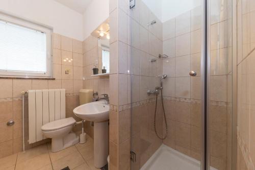een badkamer met een douche, een toilet en een wastafel bij Apartments Leonarda in Murter