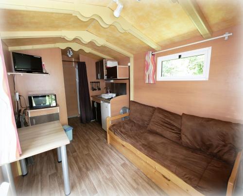 a living room with a couch and a window at Auberge de la Rivière in Foncine-le-Haut