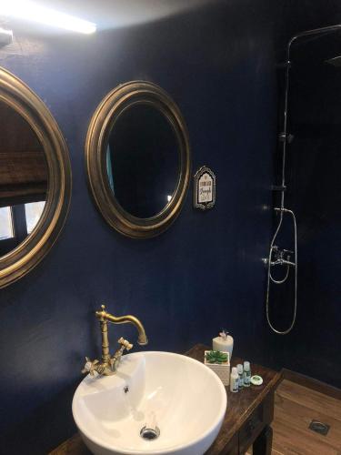 a bathroom with a sink and two mirrors on the wall at Soul boutique hotel in Monodendri