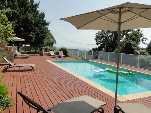 a swimming pool with an umbrella on a deck at Mas De Sarjac in Saint-Andéol-de-Vals