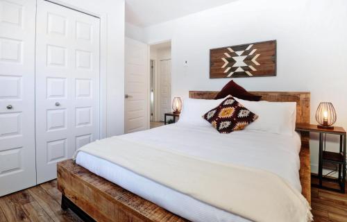 a bedroom with a white bed with a wooden headboard at 07 Chemin des Cascades in Stoneham