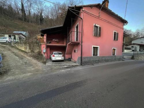 a pink house with a car parked in front of it at Casa Luzieth in Piani