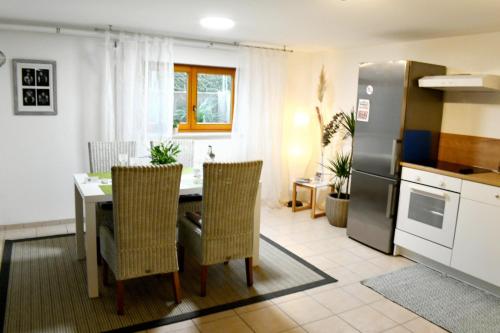 a kitchen and dining room with a table and a refrigerator at Apartment Souterrain Bühl Vimbuch Familie Bork in Bühl