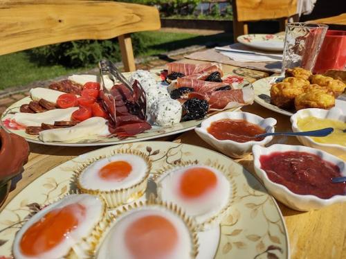 una mesa con platos de huevos y otros alimentos en Podrum Miljević en Ledinci