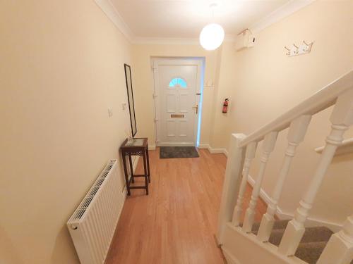 an empty hallway with a staircase and a white door at Friars Walk 2 with 2 bedrooms, 2 bathrooms, fast Wi-Fi and private parking in Sittingbourne