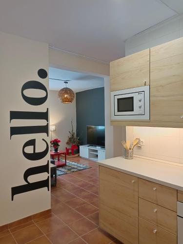 a kitchen with a microwave and a living room at Neverending Nature León in Tremor de Arriba