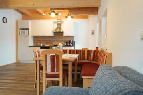 ein Esszimmer und eine Küche mit einem Tisch und Stühlen in der Unterkunft Zenauerhof in Sankt Martin bei Lofer