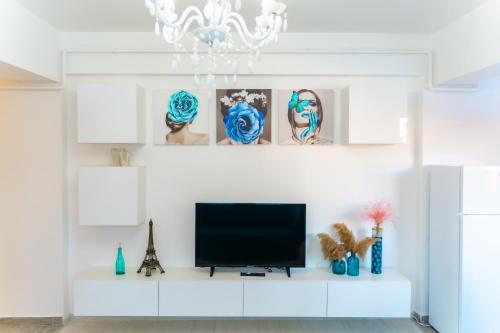 a living room with a tv on a white wall at Unique Hotel Apartments Iasi in Iaşi