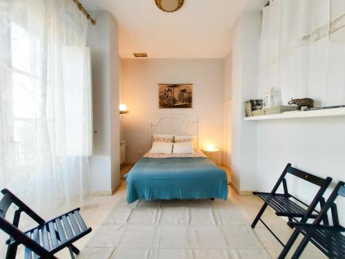 a bedroom with a bed and two chairs at ATICO DUPLEX ALAMEDA de HERCULES GRAN TERRAZA in Seville