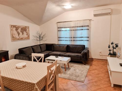 - un salon avec un canapé et une table dans l'établissement Village experience - Skadar lake, à Virpazar