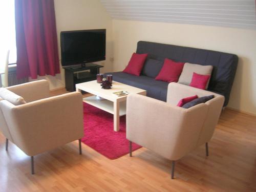 ein Wohnzimmer mit einem Sofa und einem Tisch in der Unterkunft Gemütliches Ferienhaus Mainz in Mainz