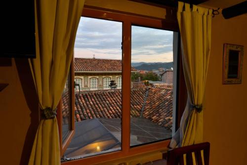 a window with a view of a roof at Hotel Posada del Angel in Cuenca