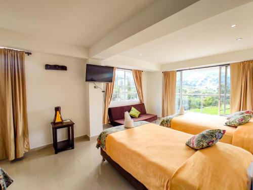 a hotel room with two beds and a tv at Hotel Boutique Palmas de Salento in Salento