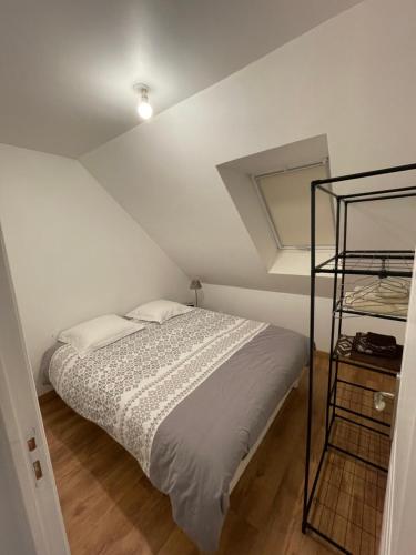 a white bedroom with a bed and a shelf at Apparemment Parigne l’évêque in Parigné-lʼÉvêque