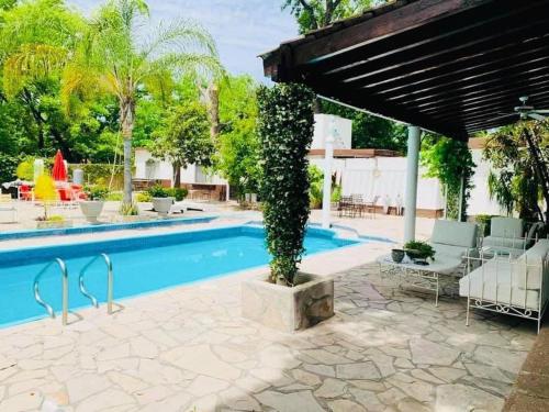 a swimming pool with a pergola next to a resort at La Casita Inn Bustamante in Bustamante