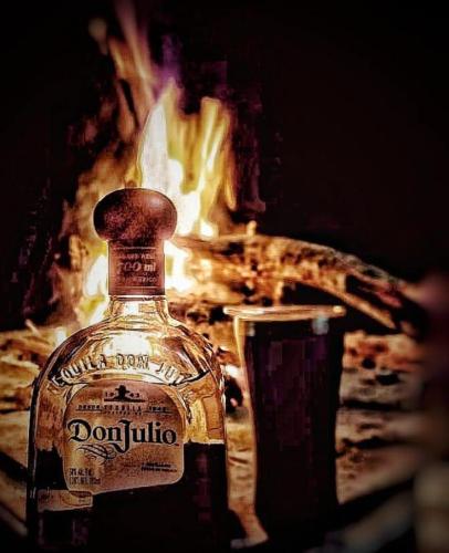 a bottle of alcohol sitting next to a fire at La Casita Inn Bustamante in Bustamante
