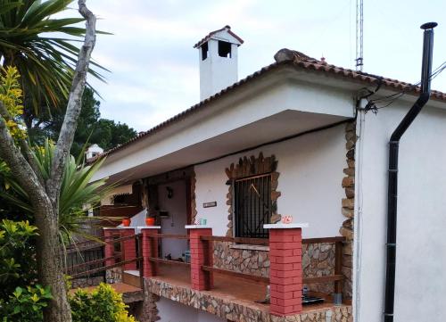 a small white house with a red and white porch at Apartamento Can Jaramills in Tordera