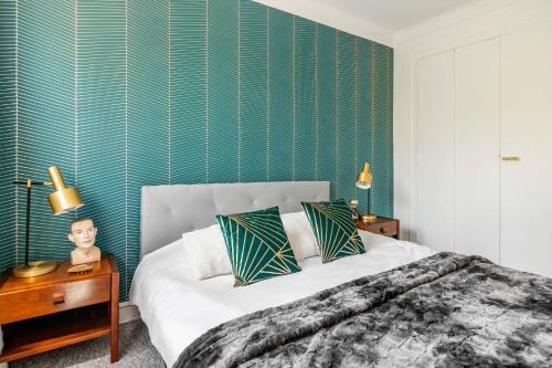 um quarto com uma cama e uma parede verde em Bel appartement avec garage sur l'île de Nantes em Nantes