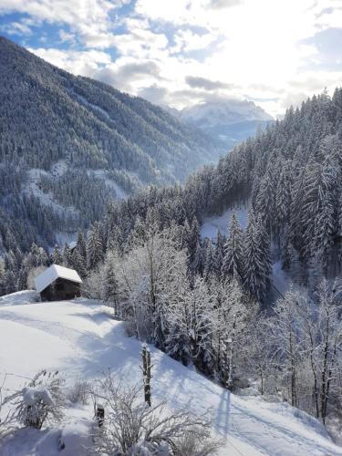 a snow covered hillside with a cabin in the distance at Lüch da Morgnun in San Vigilio Di Marebbe