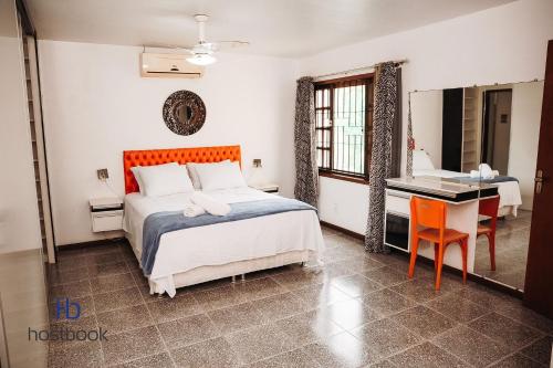 a bedroom with a bed and a desk and a bed at Casarão do Bosque a 200 m da praia | ROUR218 in Rio das Ostras