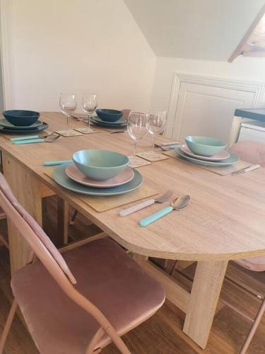 a wooden table with bowls and plates and wine glasses at Mount Bolton Apartment in Portlaw