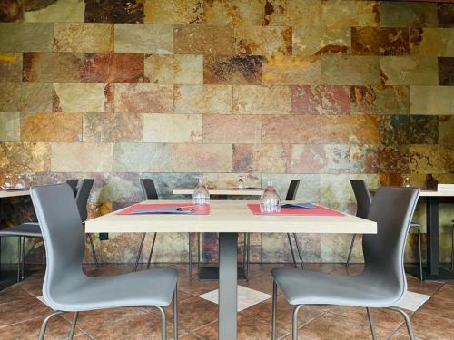 a table with chairs in front of a brick wall at Hotel Yerri in Estella